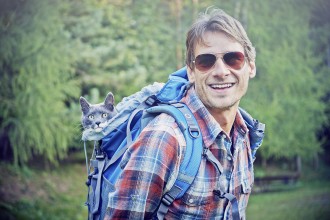 man hiking with cat in backpack