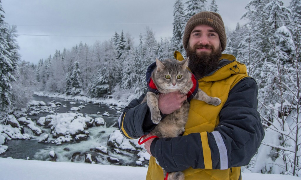 man holding cat in snow