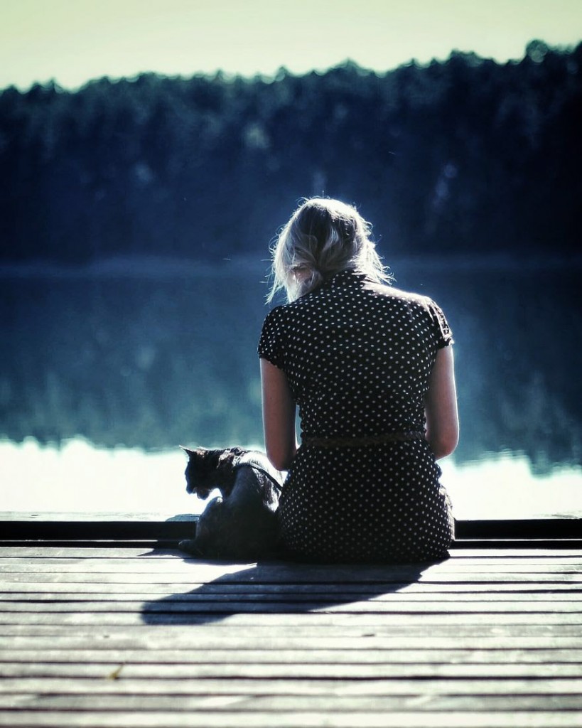 cat and owner sitting on dock