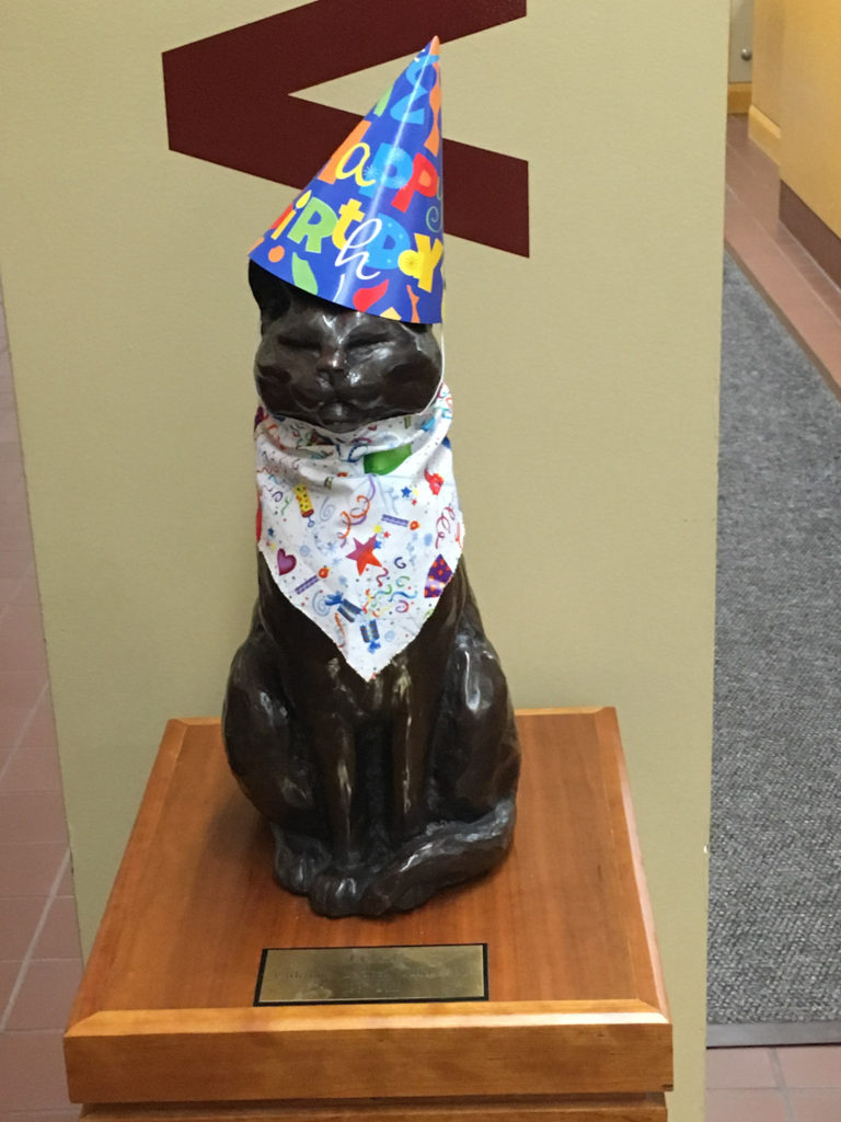 Toff cat statue wearing birthday hat