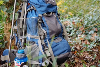 backpack and litter scoop in woods