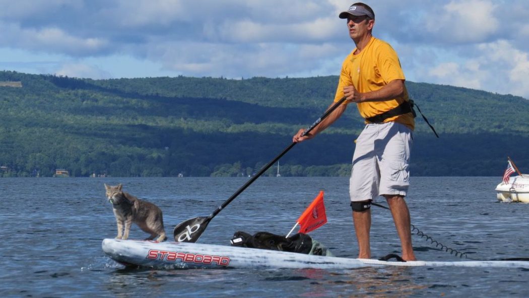 Dr. Ken paddle boarding with his cat Bug
